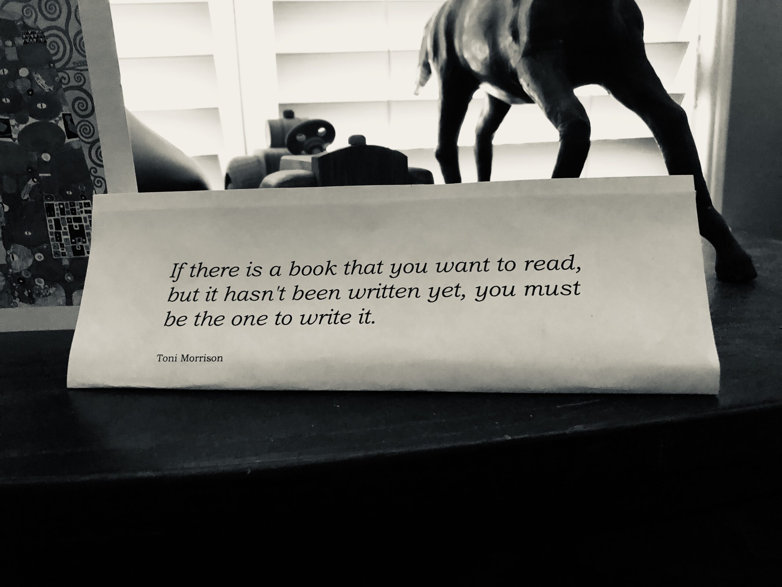 Morrison quote in Little's home office. It reads "If there is a book you want to read, but it hasn't been written yet, you must be the one to write it." Toni Morrison.